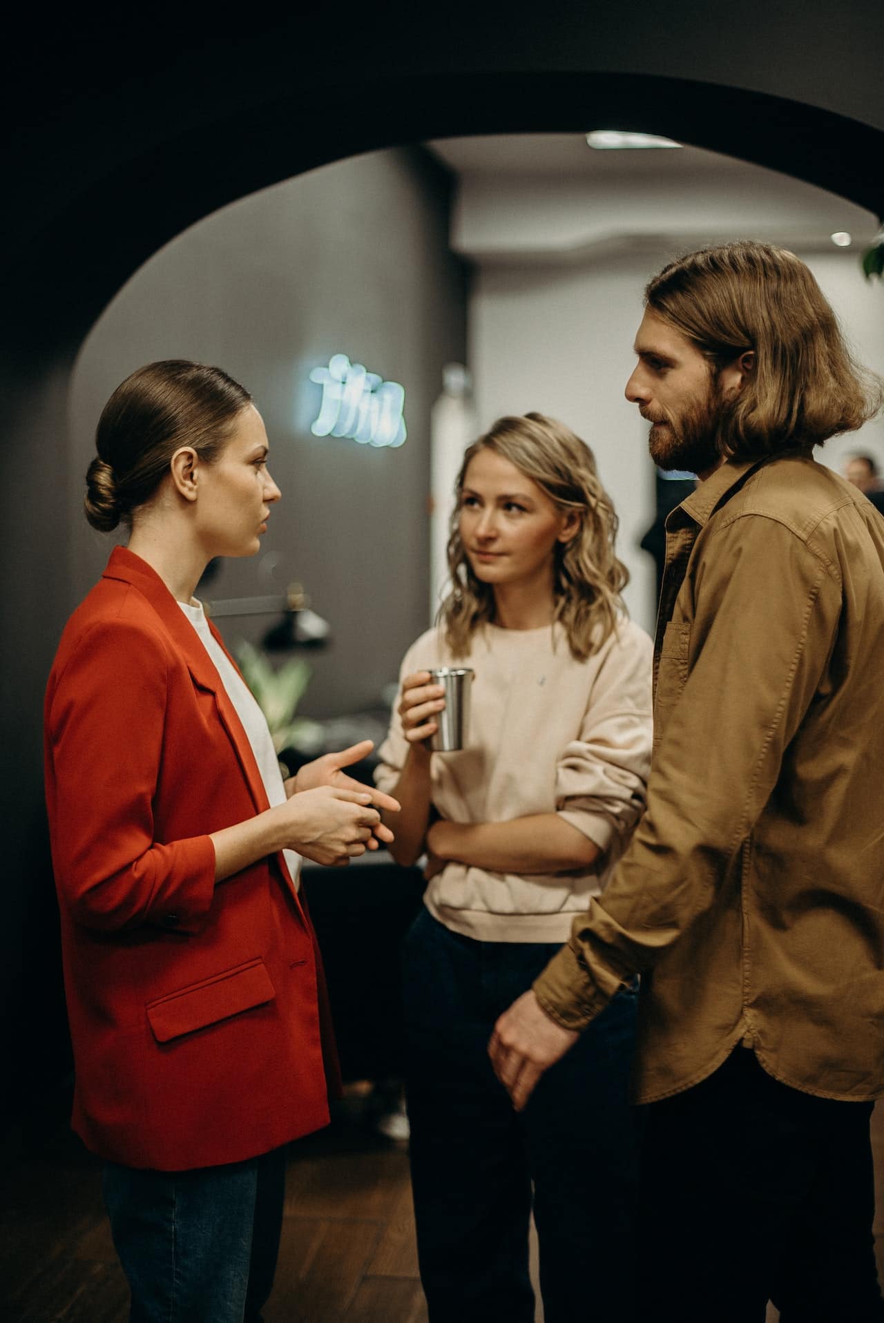 A group of workers chatting informally at work, with serious expressions on their faces.